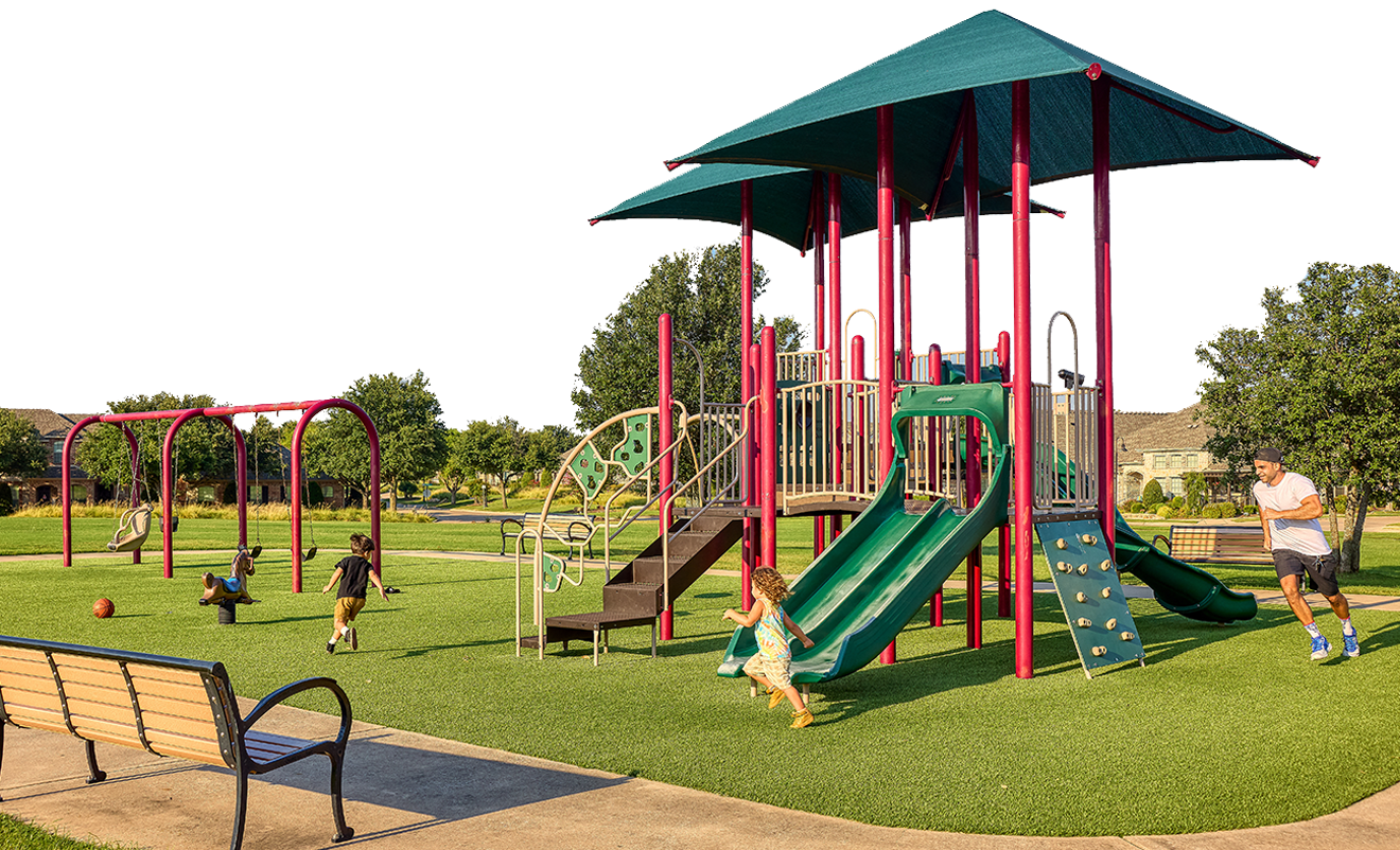 An image of a man and two children running around a playground structure at Meadows Park.