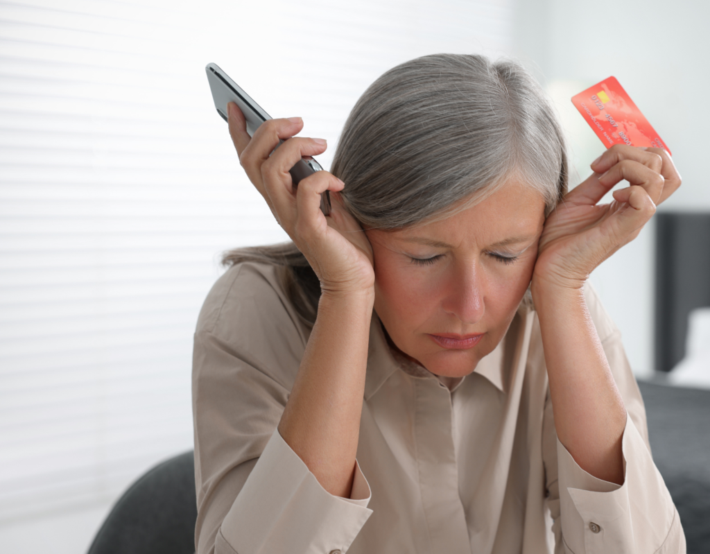 Image of frustrated woman holding cell phone and credit card
